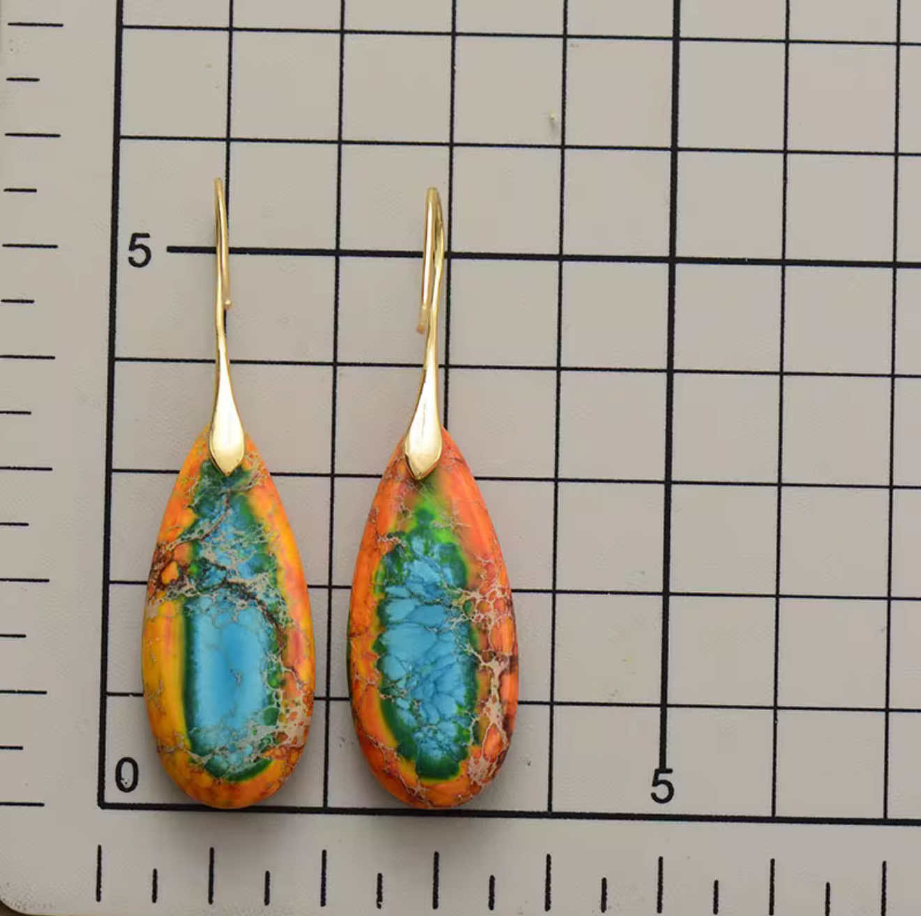 Sunfire Tide Jasper Drop Earrings with multicolored jasper teardrop stones and gold-tone hooks on measurement grid background