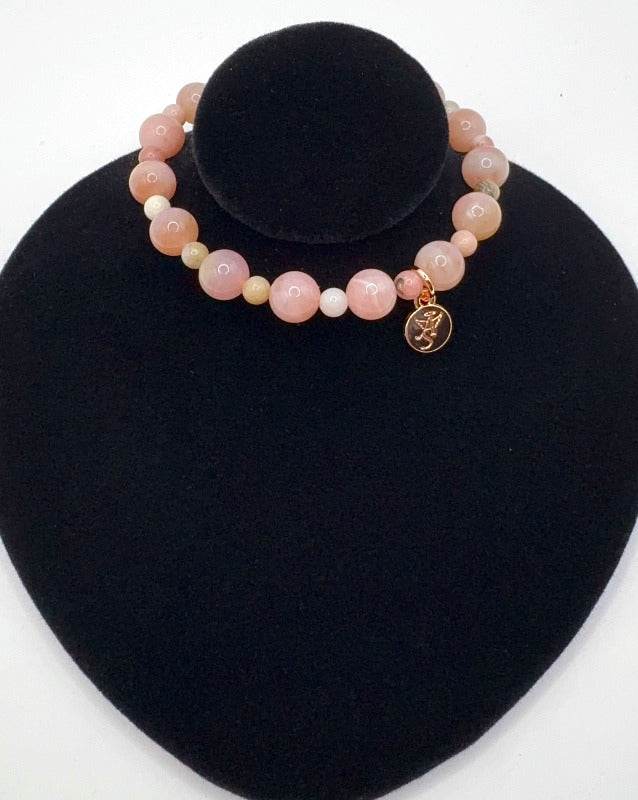 Romantic Love Bracelet featuring pink opal gemstones for love and heart healing displayed on black stand