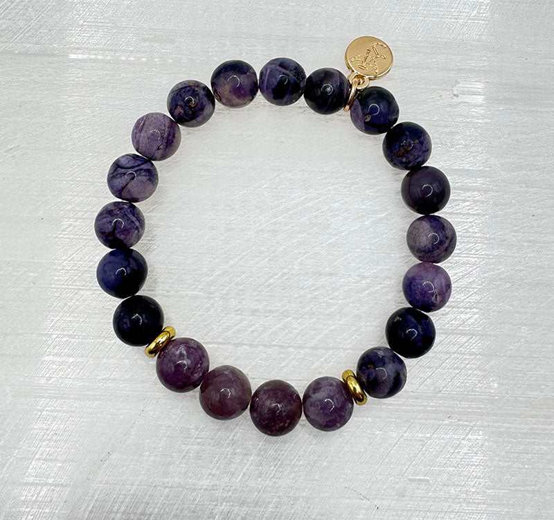 Sugilite and Lepidolite stretch bracelet with gold-tone spacers and logo charm in lavender and violet hues