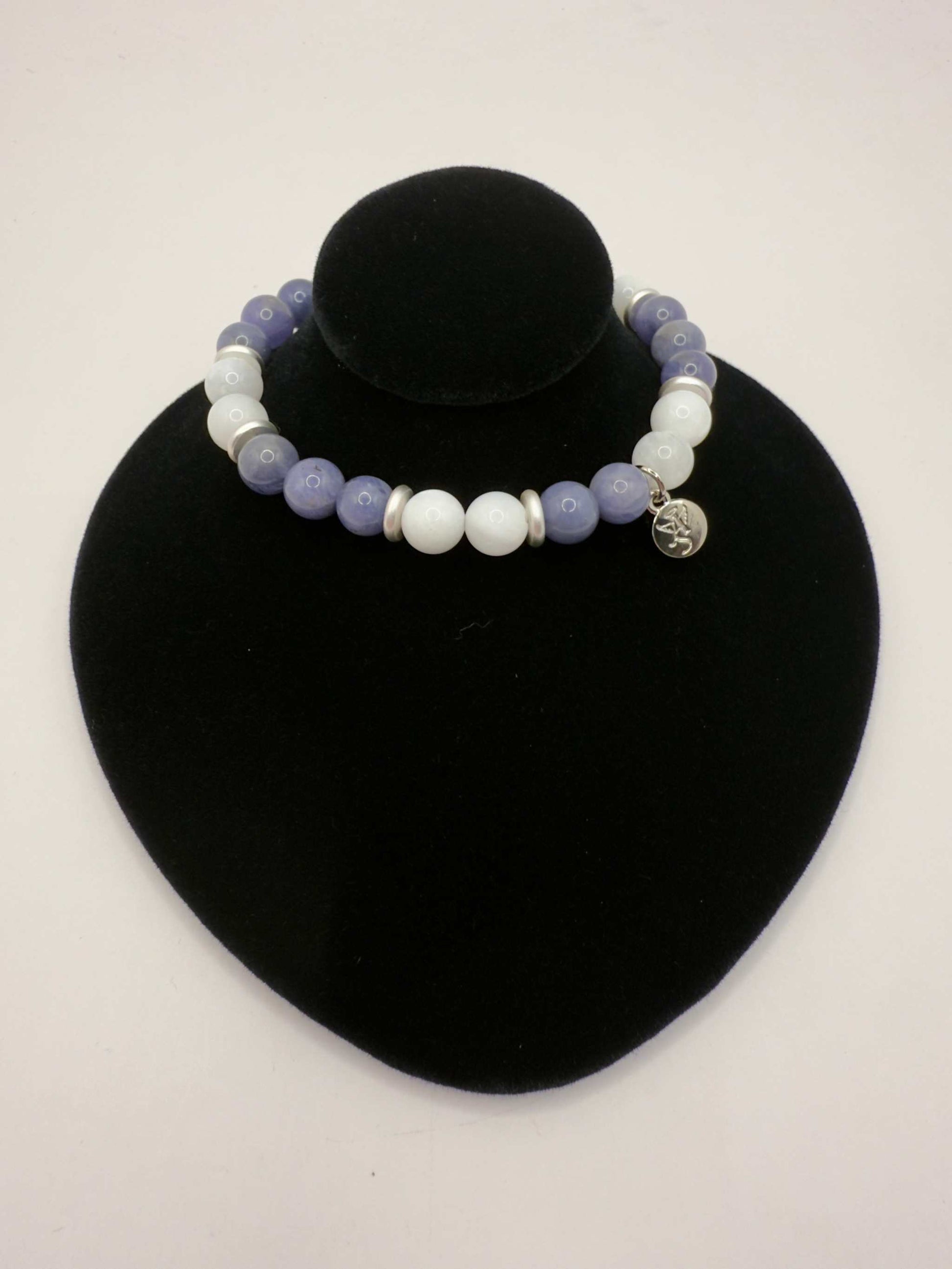 Moonlight Metamorphosis Bracelet with tanzanite and moonstone beads on black display stand