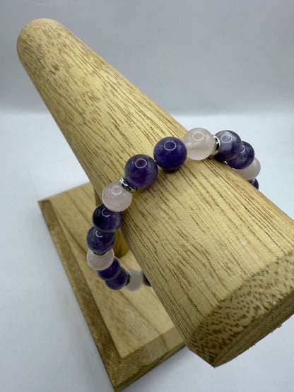 Harmony bracelet with amethyst and rose quartz beads on wooden display stand