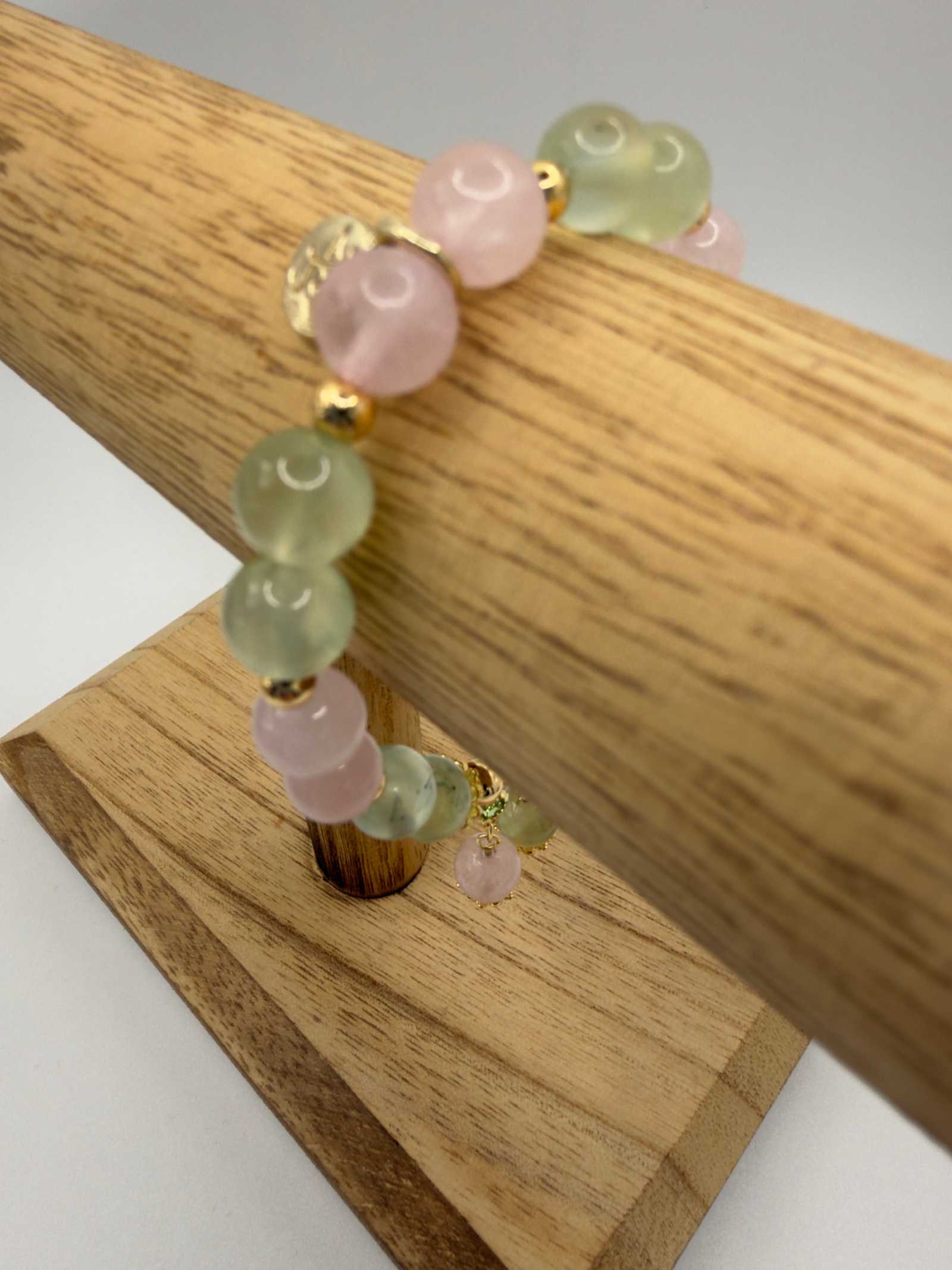 Close-up of Love in Bloom Bracelet with rose quartz and prehnite beads showcasing soft pink and green tones