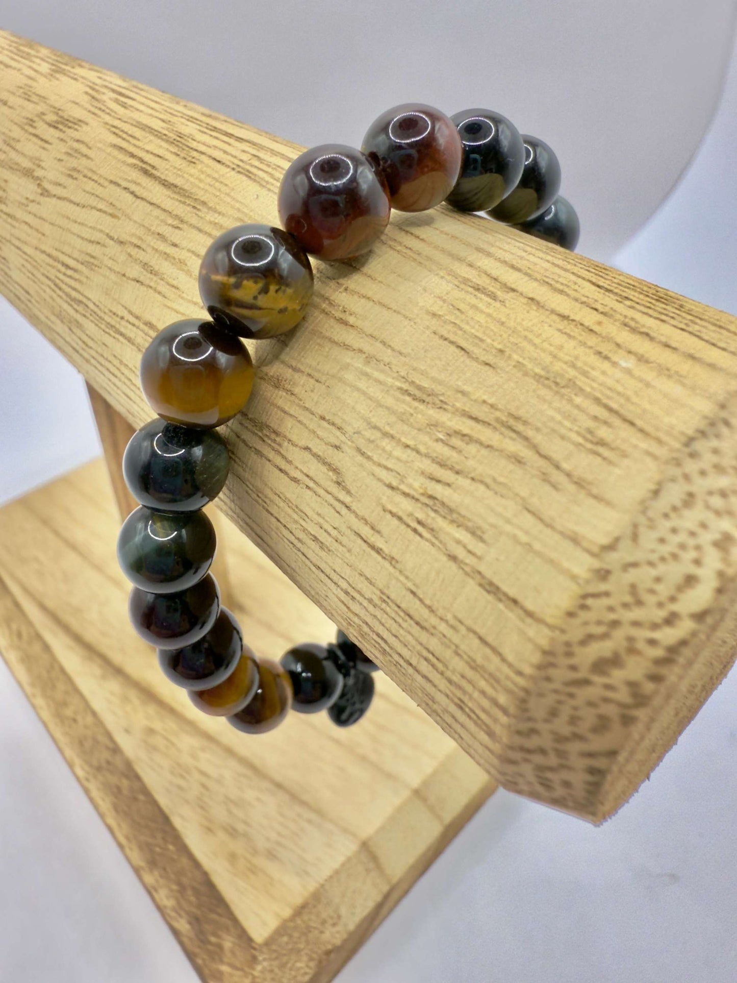Superior Energy Protection Bracelet with Black Tourmaline and multicolor Tiger Eye beads on wooden display