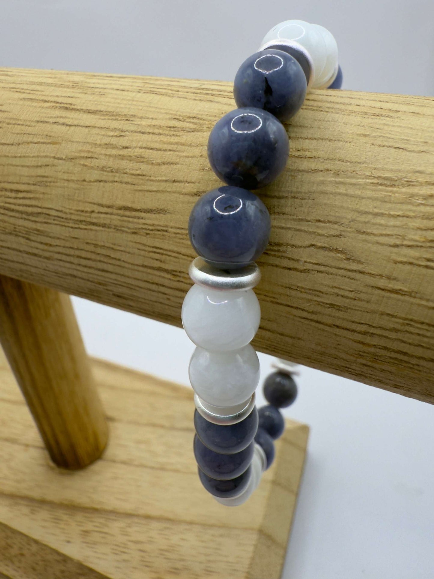 Moonlight Metamorphosis Bracelet featuring tanzanite and moonstone beads on a wooden display