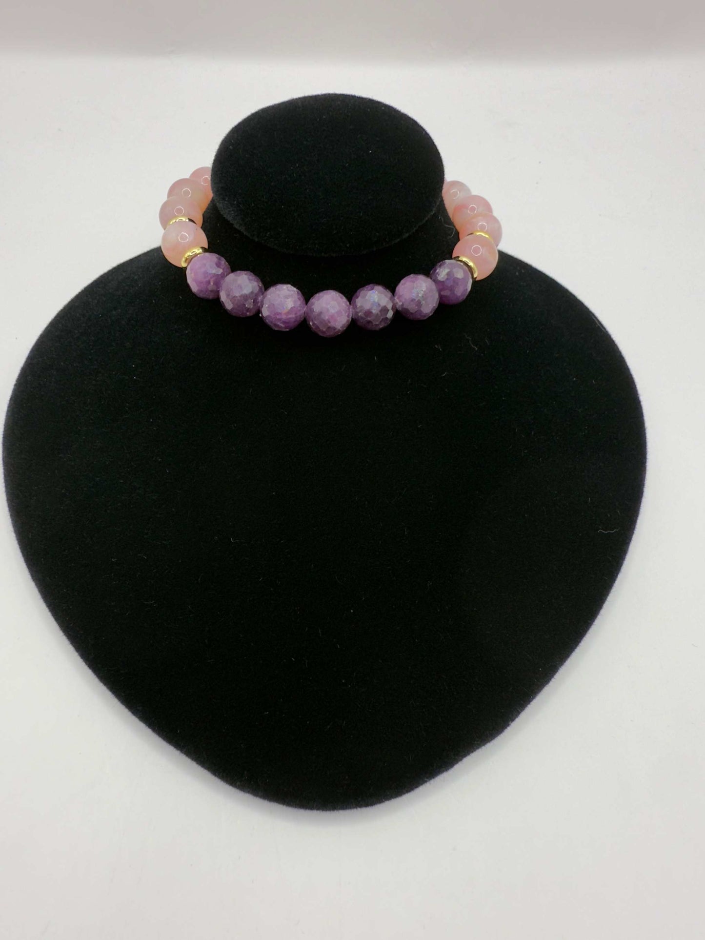 Limited edition Wicked Bracelets Glinda with pink opal and ruby gemstones on black display