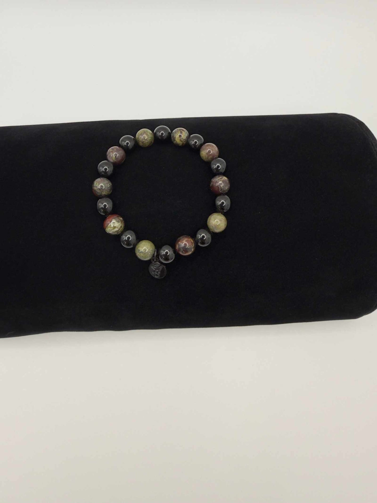Black Tourmaline and Bloodstone protection bracelet with silver angel charm on black background