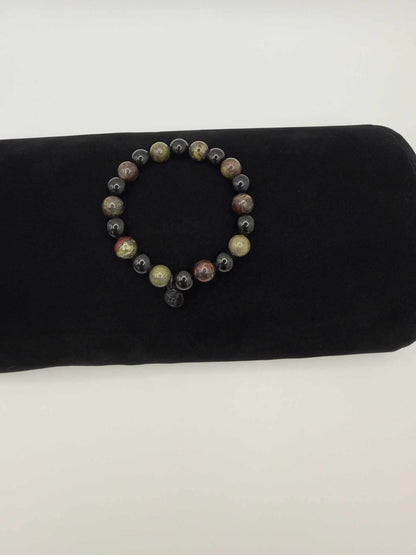 Black Tourmaline and Bloodstone protection bracelet with silver angel charm on black background