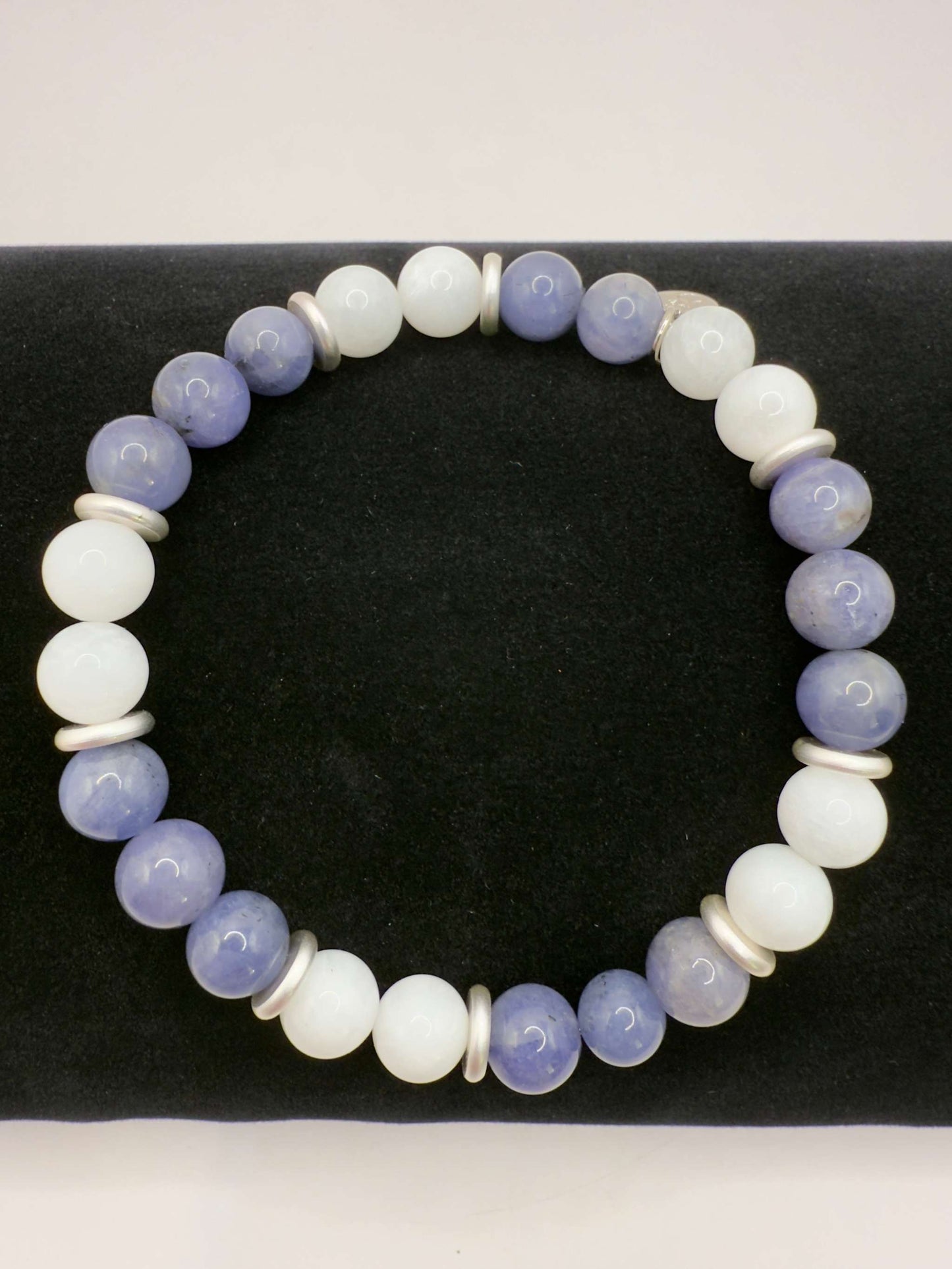 Moonlight Metamorphosis Bracelet with tanzanite and moonstone beads on a black background
