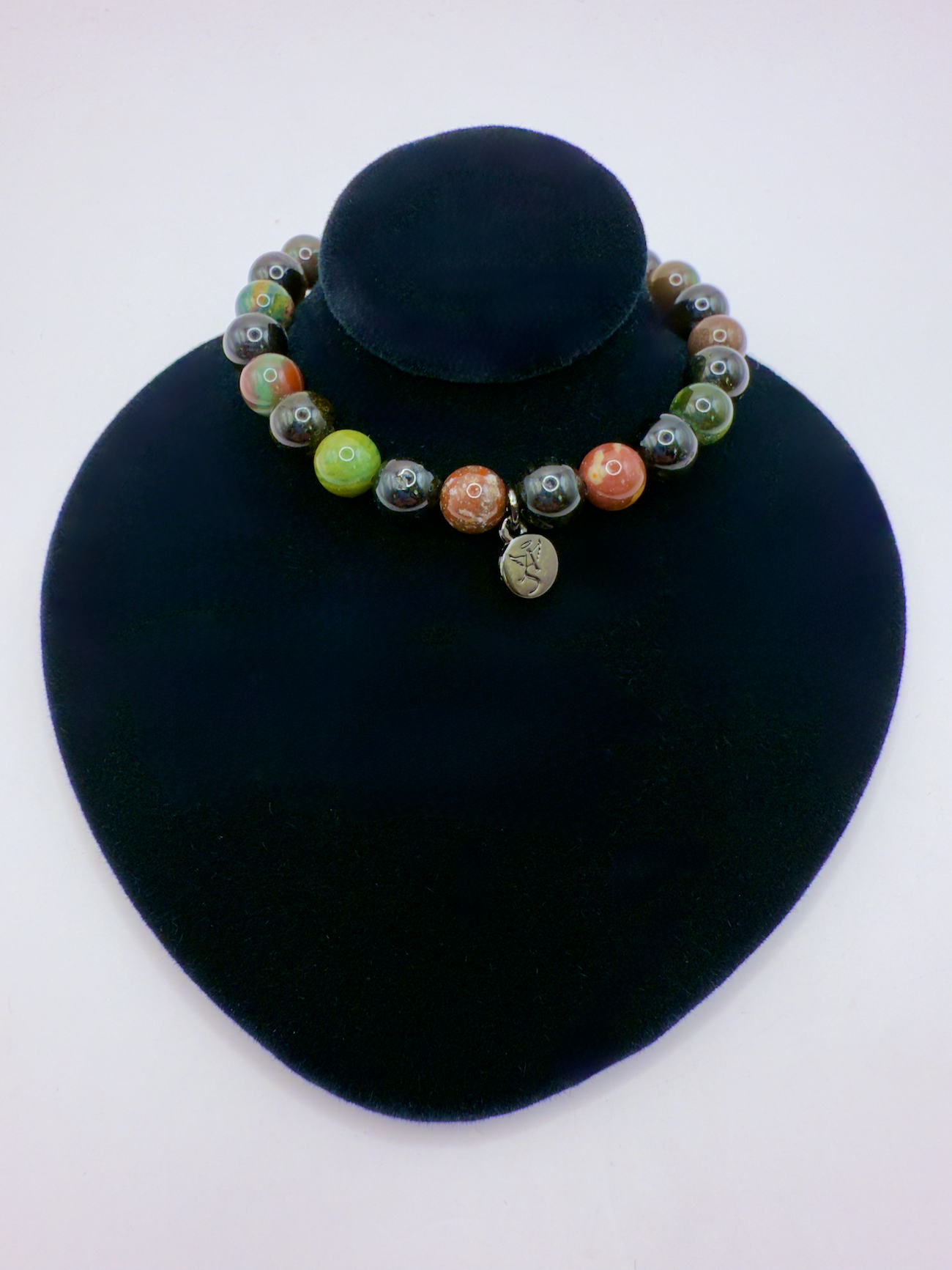 Black Tourmaline and Bloodstone protection bracelet with silver-plated angel charm on black display bust