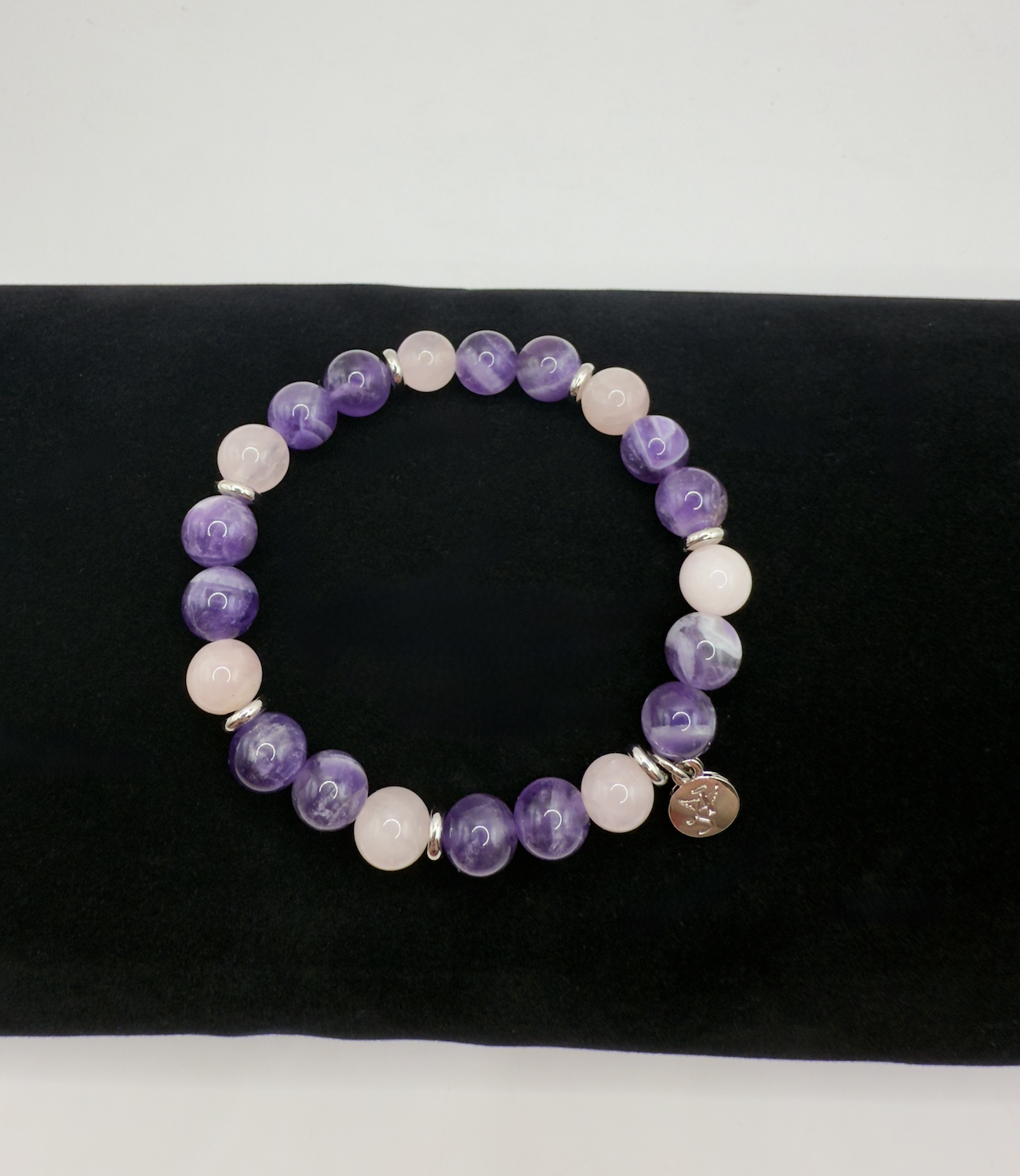 Harmony Bracelet with natural amethyst and rose quartz beads on black cushion background