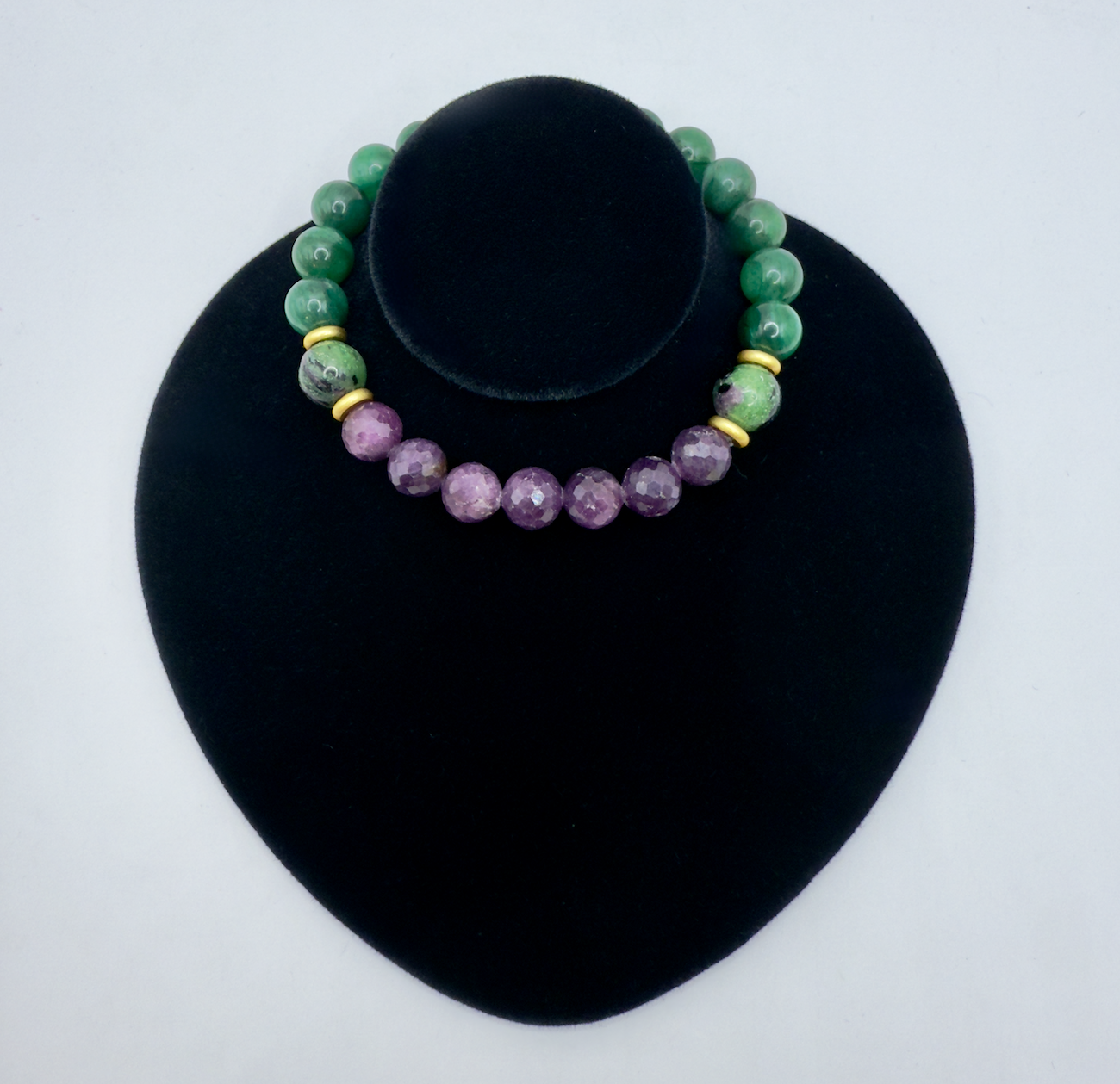 Limited edition Wicked Bracelets featuring Elphaba design with emerald, ruby, and zoisite beads on black display stand