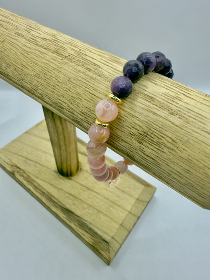 Limited edition Wicked Bracelets Glinda with pink opal and ruby beads on wooden display stand