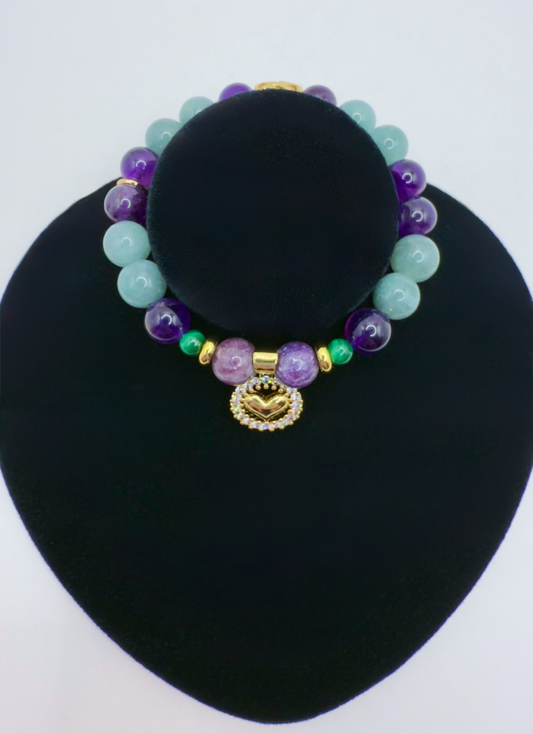 Prosperity Abundance Bracelet with Jade, Amethyst, Lepidolite, Malachite, gold accents, and heart charm on black display stand