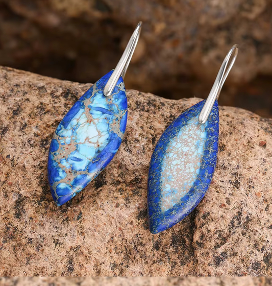 Azure Path Jasper Drop Earrings with elongated blue jasper stones and silver-tone hooks on stone background
