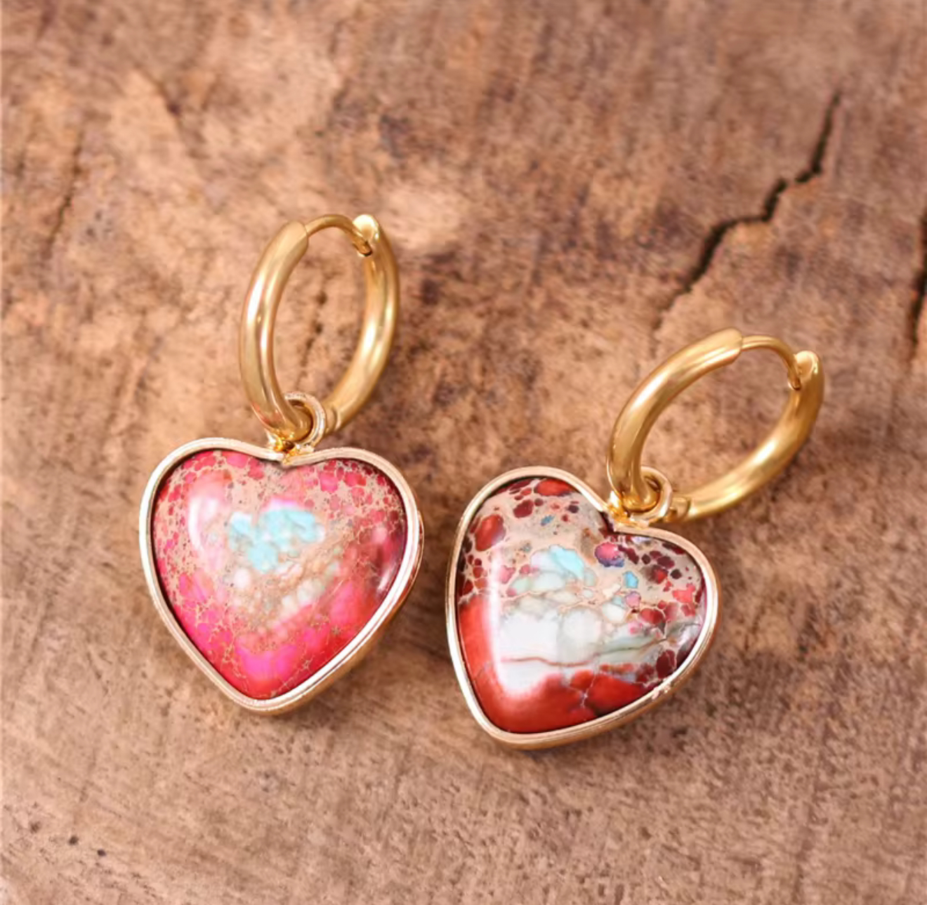 Crimson Hearth Jasper Huggie Earrings heart-shaped stone earrings with gold-tone huggie hoops on wooden background