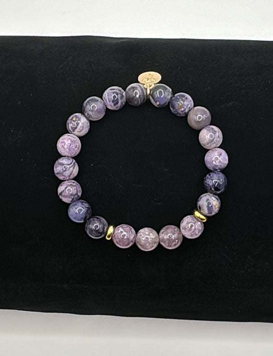 Sugilite Bracelet with 8mm purple beads and gold accents on black background